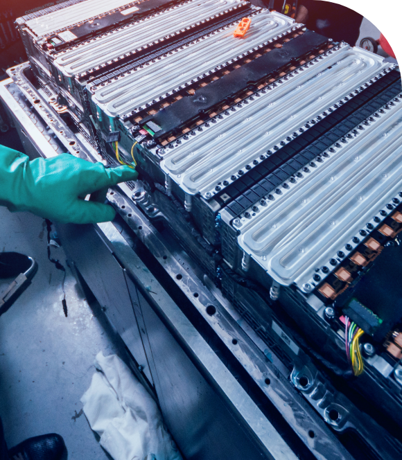 a hand with a green glove pointing to batteries | Image d’une batterie 3D